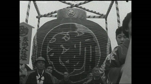 男人们和艺妓们举着大灯笼列队穿过Nakamise。视频素材