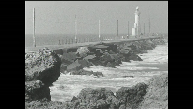 日本千叶，海浪冲击着灯塔附近的防波堤。视频下载