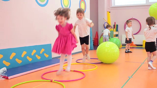 小女孩们在幼儿园和其他孩子一起蹦蹦跳跳视频素材