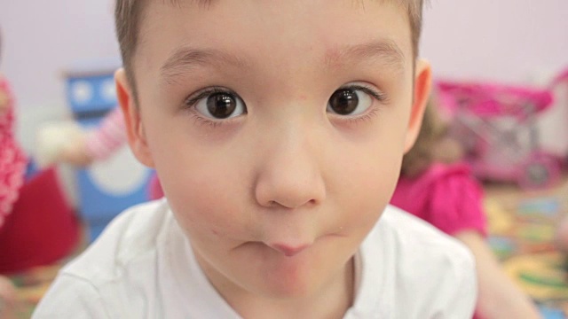 小男孩在幼儿园里做鬼脸视频素材