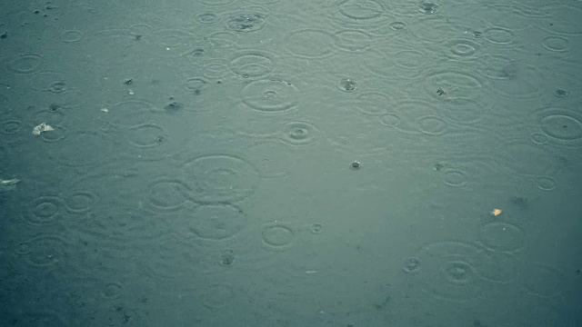 水坑里的几滴雨水的慢动作背景视频素材
