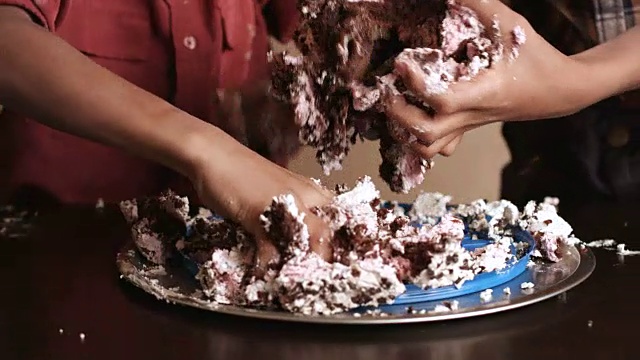 孩子们的手在捣毁蛋糕。视频素材