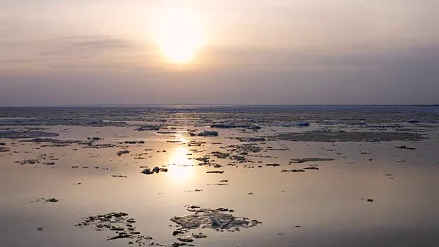 延时的日落。河上浮冰。春天冰浮在水面上视频下载
