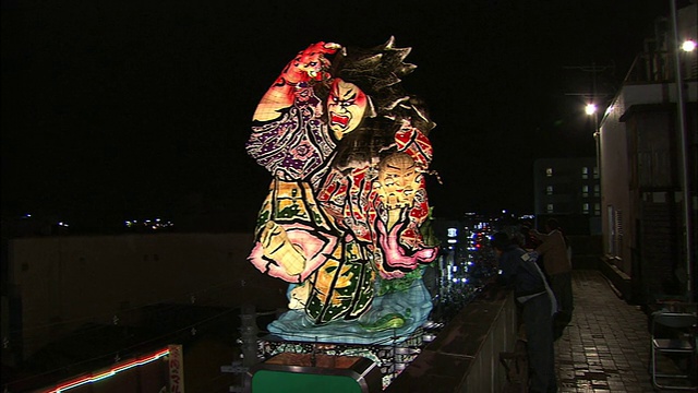 一辆巨大的游行花车描绘了一名战士从阳台上的观众面前经过。视频下载