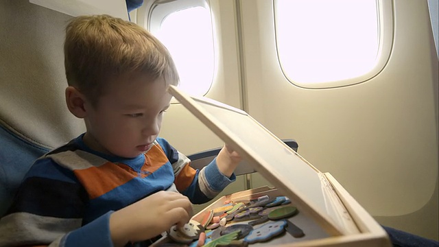 小男孩在飞机上带着木箱视频下载