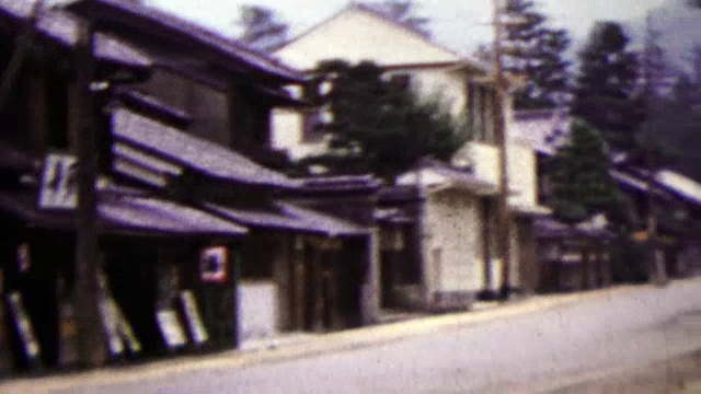 1951年:日本安静的街头女子在远处骑自行车。视频下载