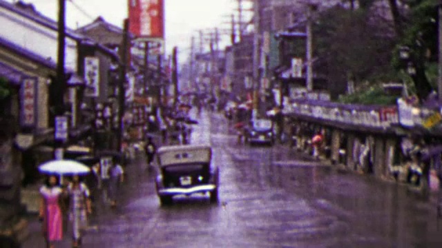 1951年:忙碌的日本商业街打着雨伞下雨。视频下载