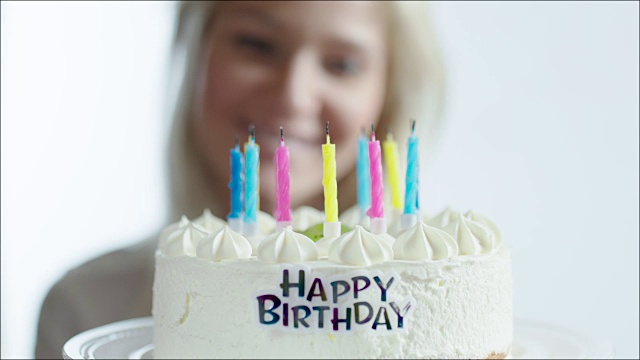 快乐女人吹灭生日蛋糕上的蜡烛视频素材