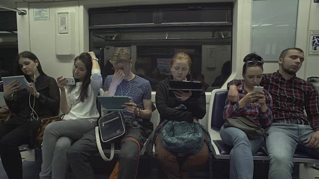 人们在乘坐地铁时使用平板电脑视频购买
