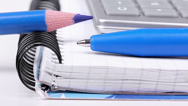 钢笔和铅笔在纸上，笔记本和计算器视频素材
