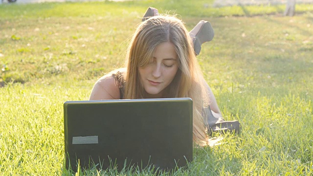 年轻女孩用笔记本电脑在户外工作视频素材