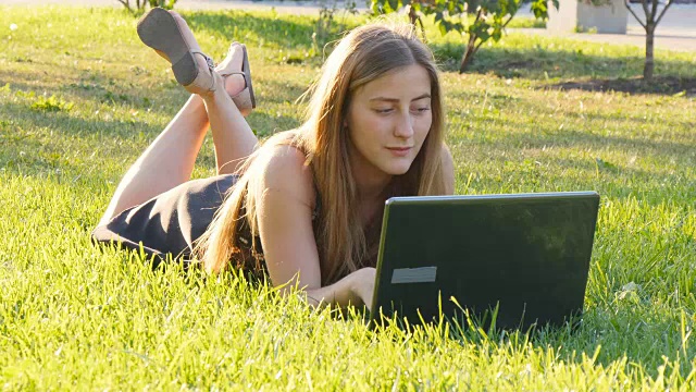 年轻女孩用笔记本电脑在户外工作视频素材