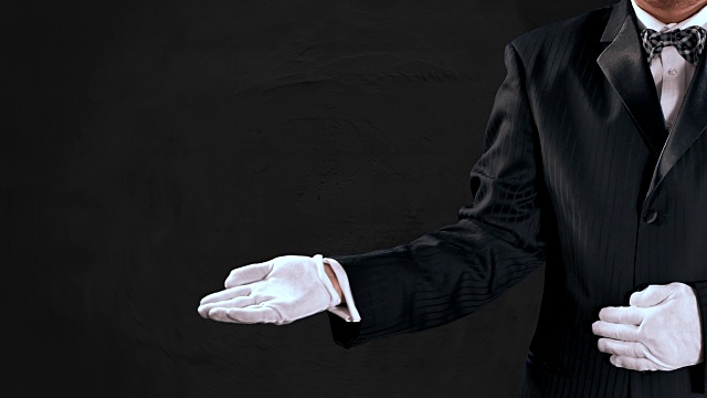 燕尾服男人的手势，打开的手揭示到中央屏幕，深灰色的背景视频下载