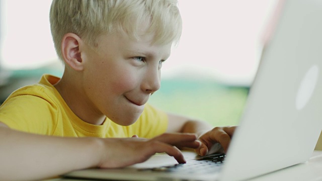 男孩在用笔记本电脑视频素材