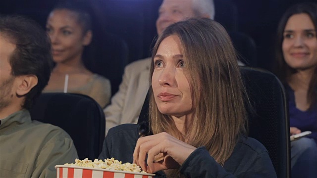 女人在电影院吃爆米花视频素材