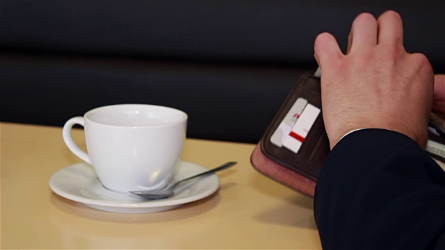在咖啡馆里，男性会用现金和信用卡付账视频下载