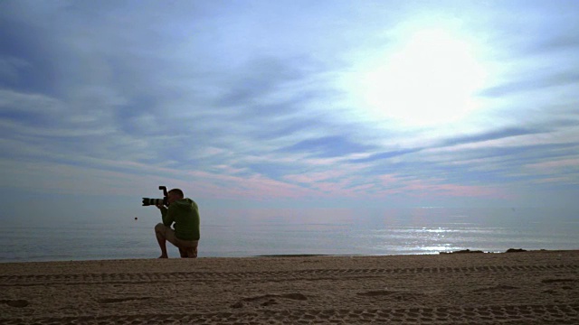 摄影师拍摄的海上日落照片。摄影师与相机在海上日落视频下载