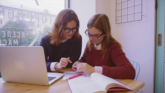 女大学生在咖啡馆学习，两个女孩朋友一起学习视频素材