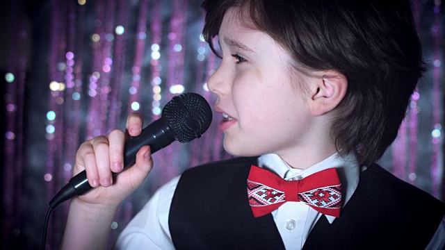 一个孩子在麦克风上唱歌的4K迪斯科圣诞镜头视频下载
