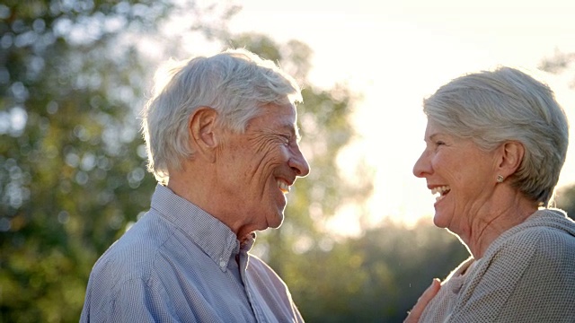 一对浪漫的老年夫妇对着太阳拍摄慢镜头视频下载