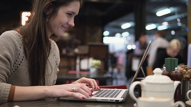 在咖啡馆用笔记本电脑工作的女商人视频下载