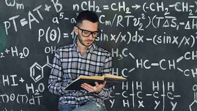 年轻的科学家在读化学和数学方程式的书，墙壁房间内部视频素材
