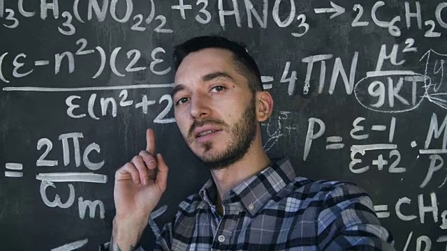 年轻的科学家男子在化学和数学方程的墙壁室内自拍视频下载