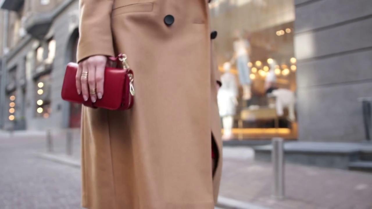 一个女人手拿红色手包走在街上视频下载