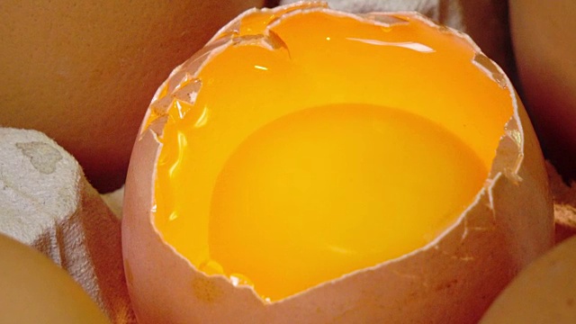 鸡蛋躺在纸板上支撑着，一个鸡蛋破了视频素材