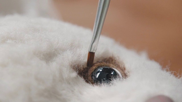 制作泰迪熊的过程:师傅画一只玩具眼睛视频素材
