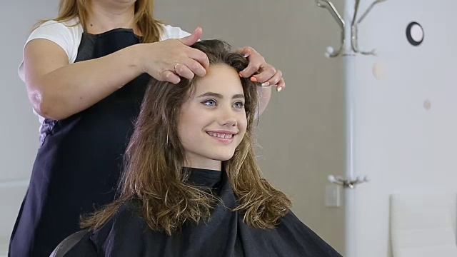 专业发型师，发型师为少女准备发型，用发夹固定头发视频素材