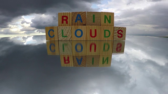 字母木制立方体玩具与单词雨云，时间流逝4K视频素材