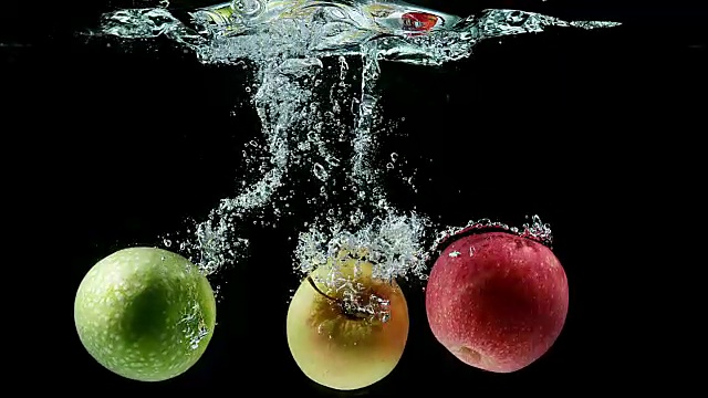 苹果，苹果，水果进入水中的黑色背景，慢镜头4K视频购买