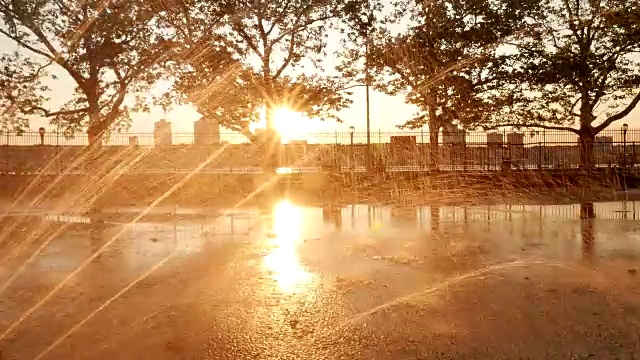 在日落时分，用镜头光晕照亮公园里的喷泉，营造浪漫气氛视频下载