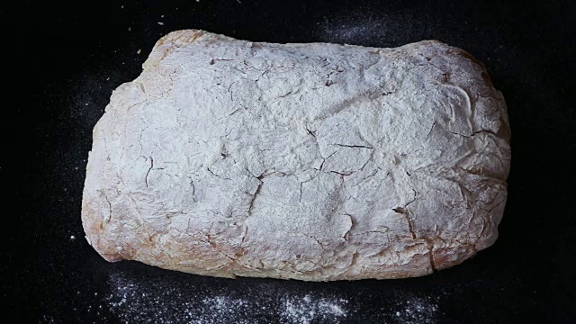 新鲜出炉的夏巴塔面包在黑色背景下缓缓落下视频素材