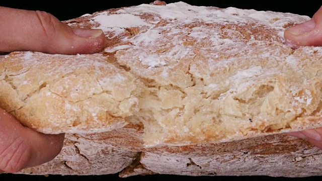 用手掰开刚烤好的面包的慢动作视频素材