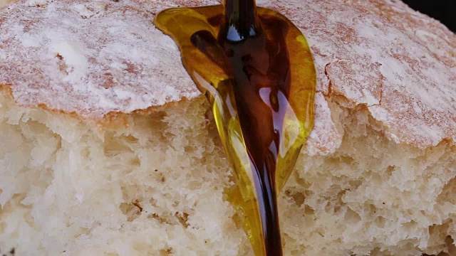 慢动作特级初榨橄榄油和香醋浇在面包上视频素材