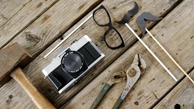 工作工具，老式相机，眼镜和假胡子排列在木板上视频下载