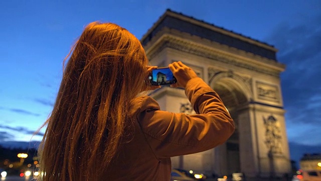 游客在晚上用智能手机拍摄凯旋门视频素材