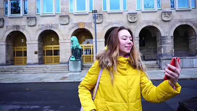 可爱的年轻女子肖像谁在视频通话使用手机，显示美丽的城市在冬天的户外视频下载