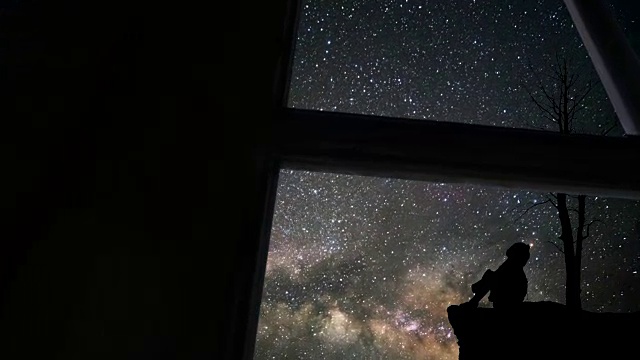 透过窗户看到孤独的女孩和银河视频素材