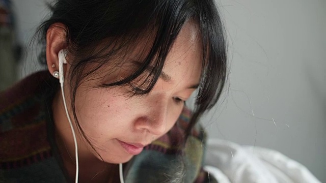 年轻的亚洲女性在听音乐视频素材