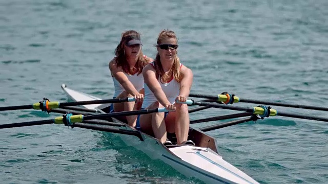 两名女运动员在阳光下划水过湖视频下载