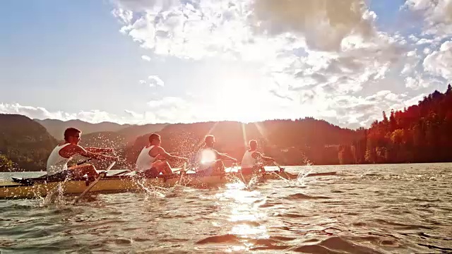男运动员在阳光下的湖面上划船视频素材