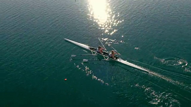 两名划手在阳光明媚的湖面上划着双桨视频下载