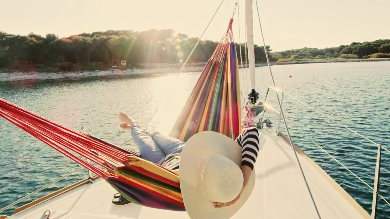 一个女人躺在一艘帆船的吊床上视频下载
