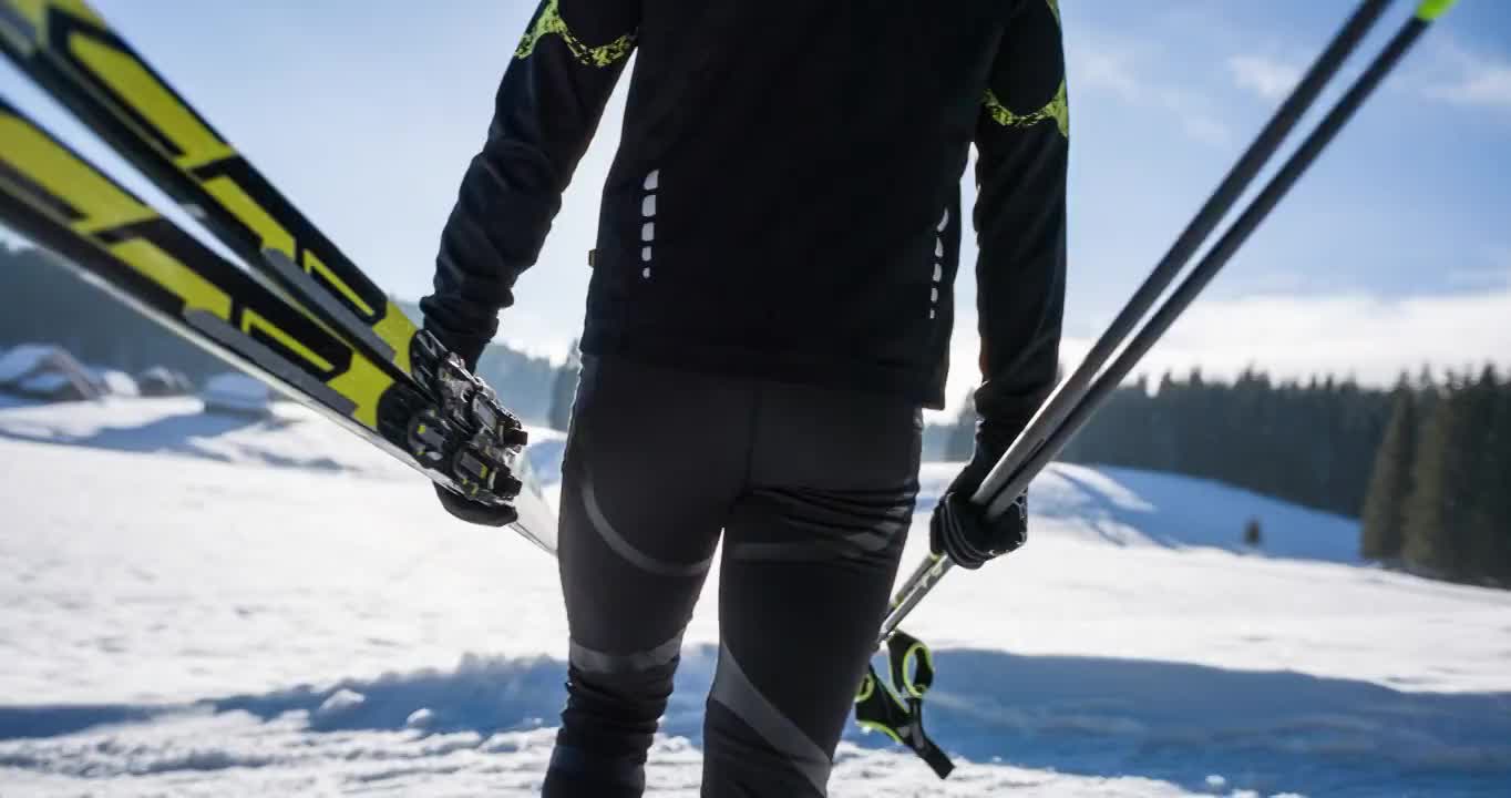 越野滑雪者在冬季景观携带他的运动设备视频购买