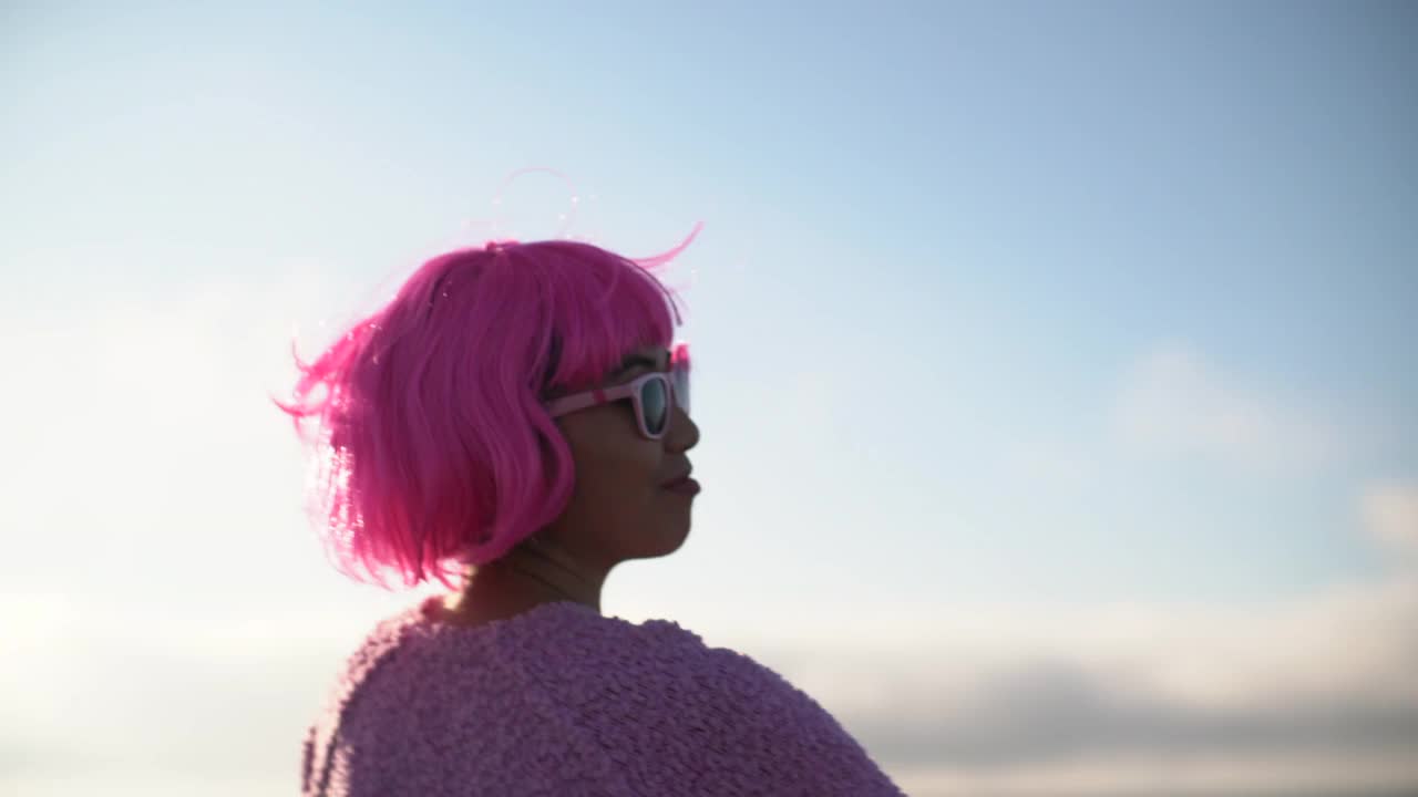 一位粉红色头发的女士在阳光下挥舞着手臂视频下载