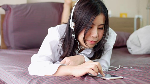 年轻的亚洲女人在听音乐视频素材