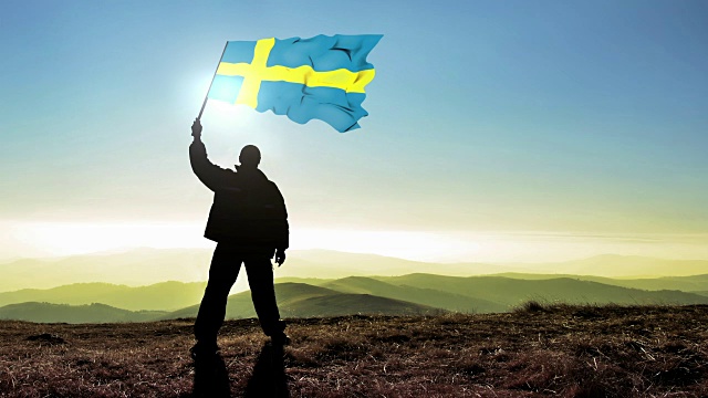 成功的剪影男子冠军在山顶挥舞瑞典国旗，Cinemagraph LOOP背景视频下载